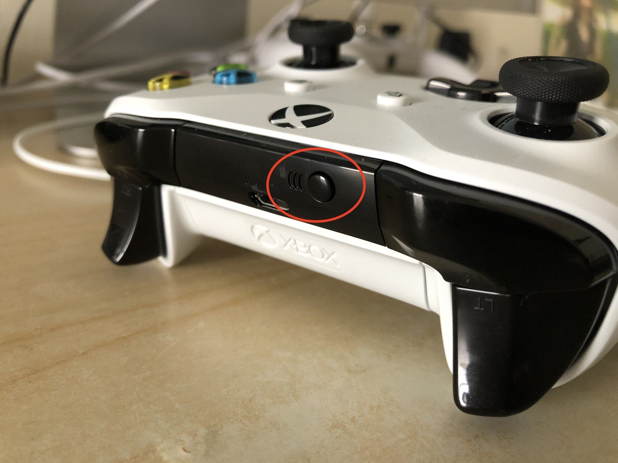 Look for the small round button on the top of the controller, near the left shoulder and trigger buttons. Press and hold it for three seconds, until the Xbox button starts blinking, to pair it with a device.