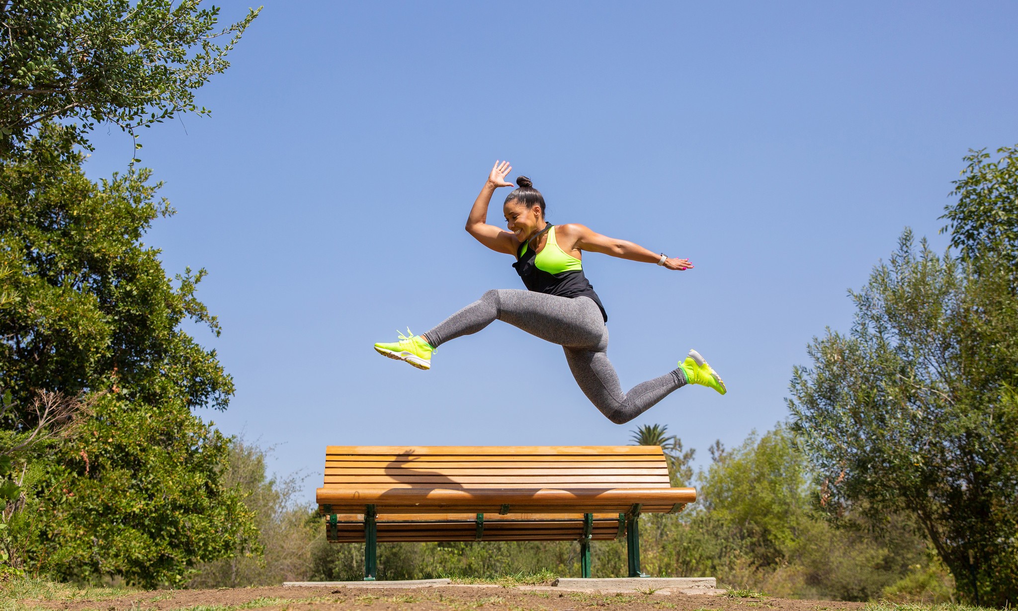 Woman jumping over bench