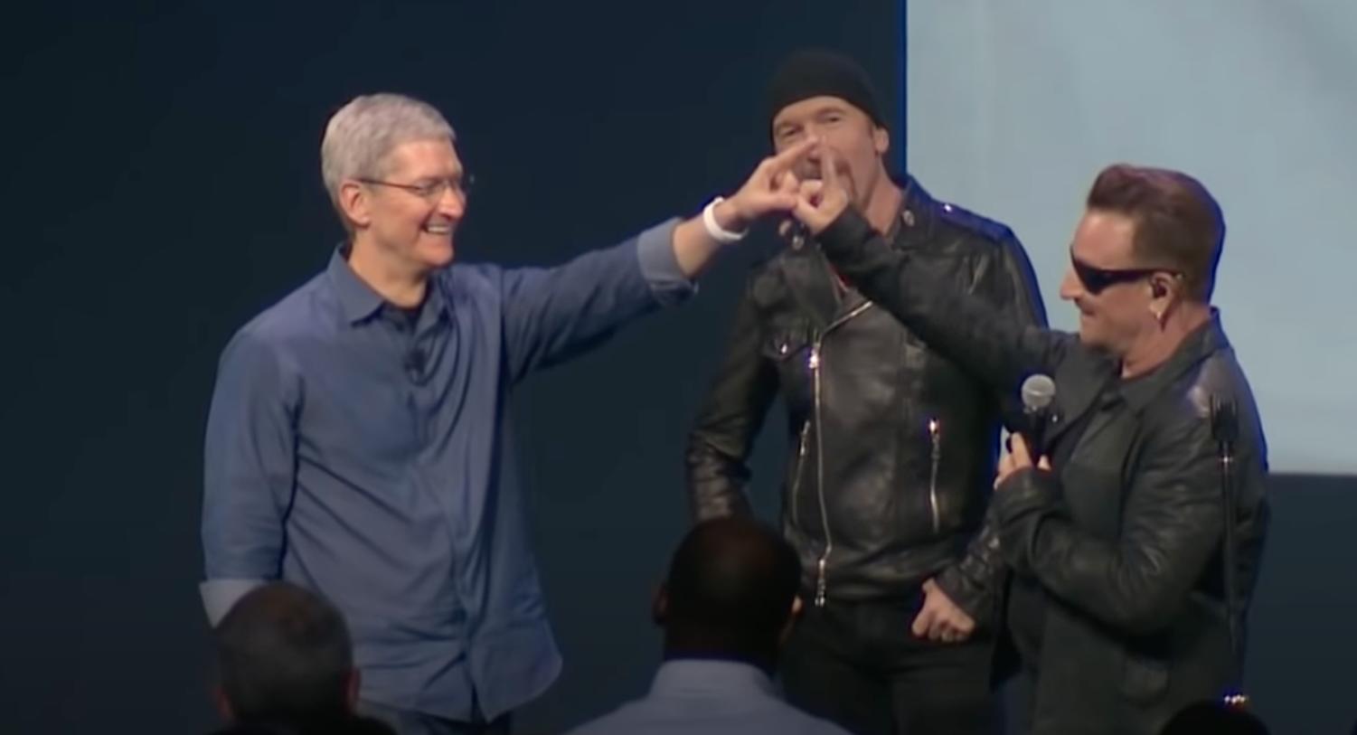 Tim Cook And Bono touching fingers