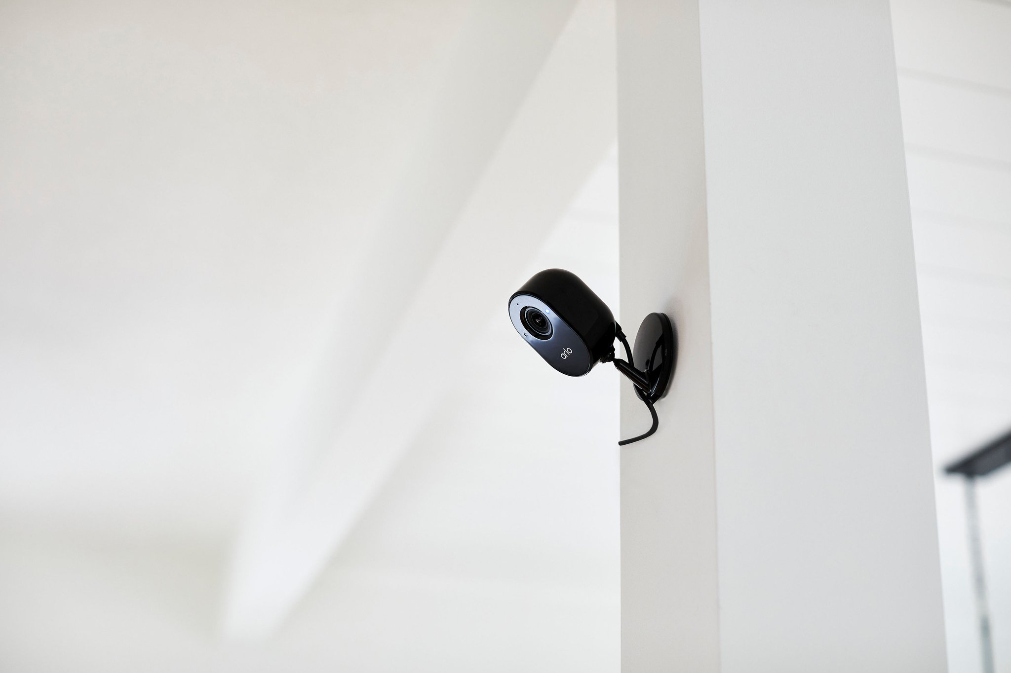 Arlo Essential Indoor Camera in black mounted on a wall