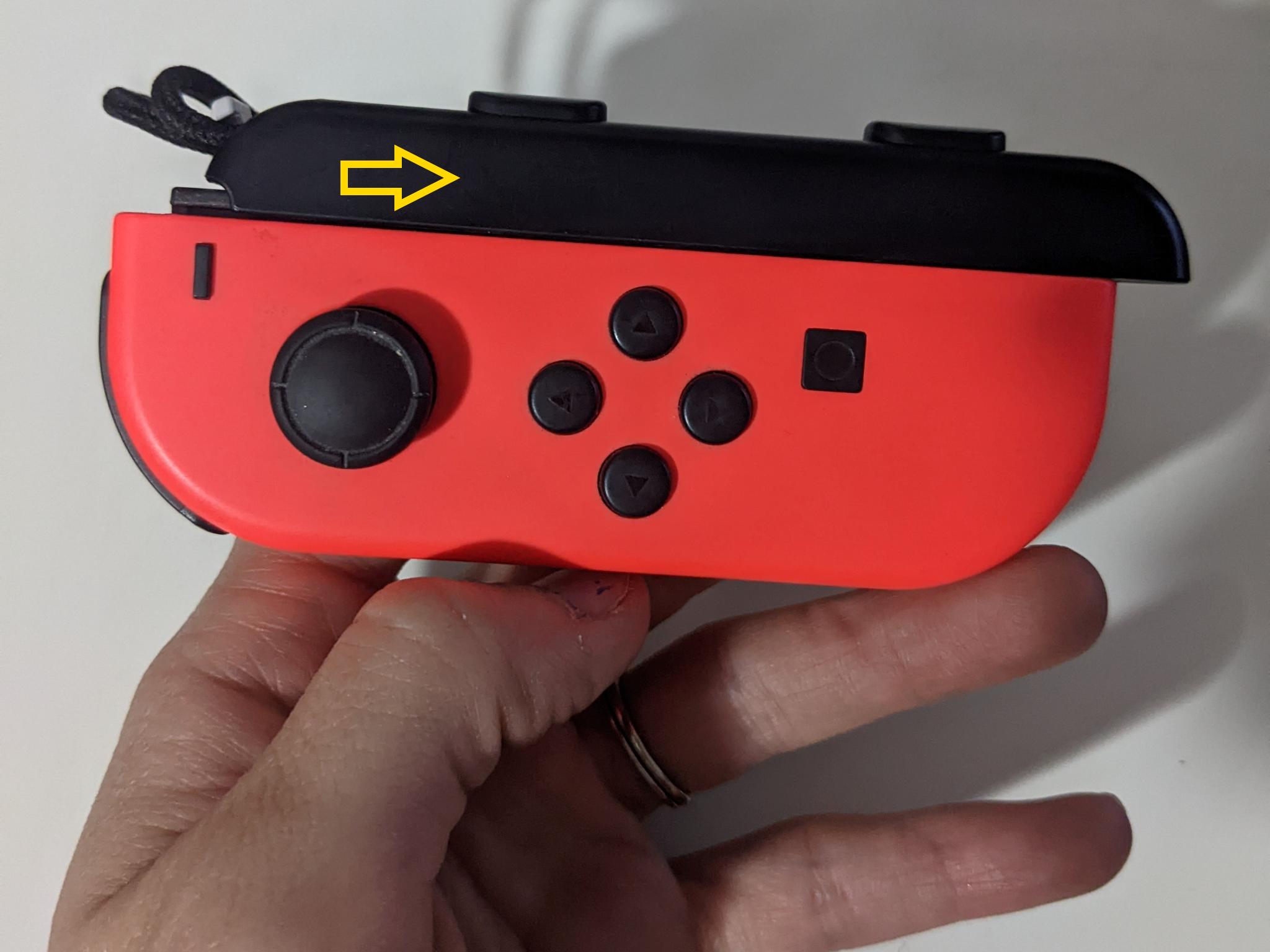 How to remove a stuck Joy-Con strap: Use the other hand to gently slide the strap away from the strap lock and off the Joy-Con