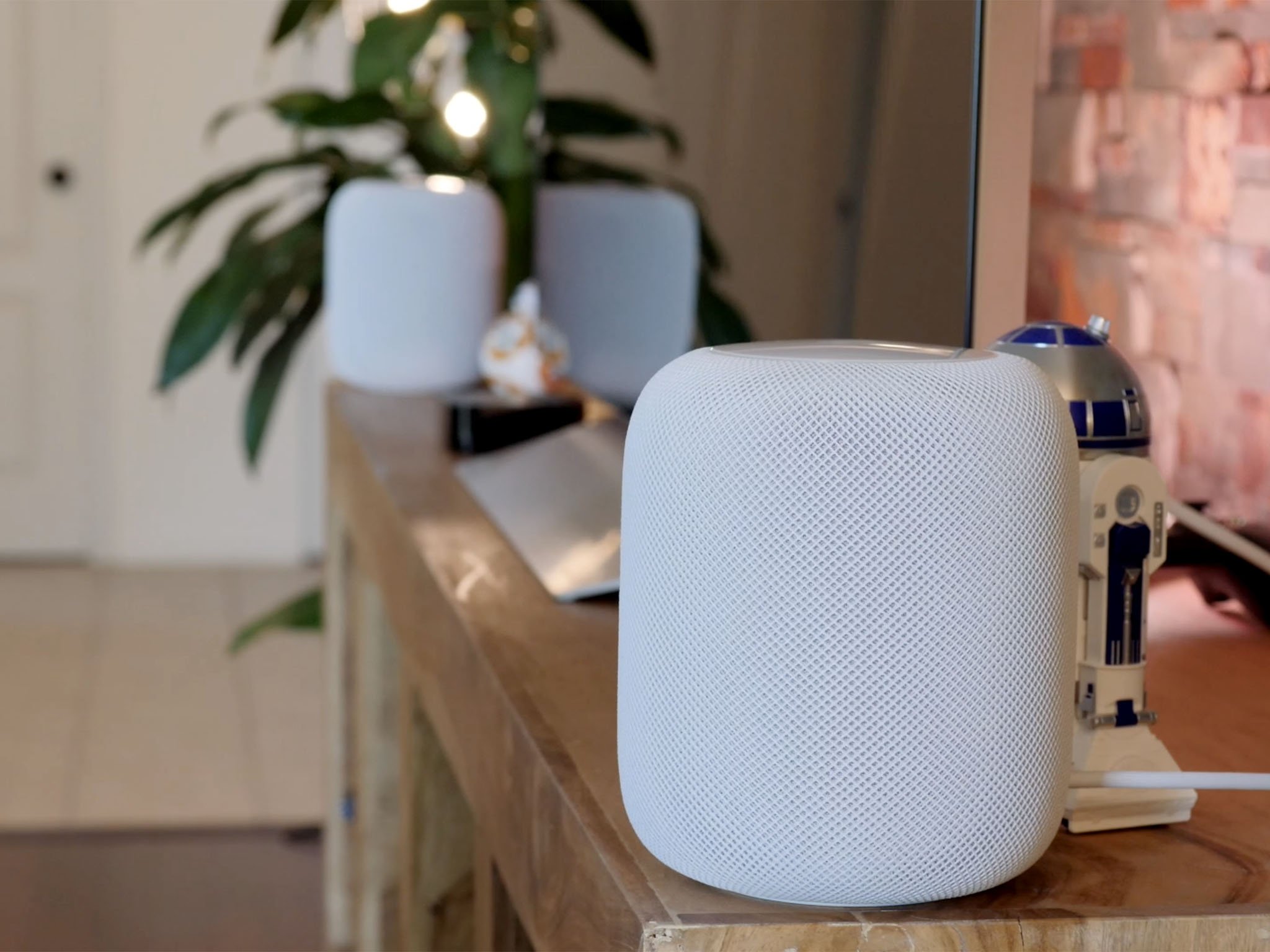 Two white homepods sitting on a television stand