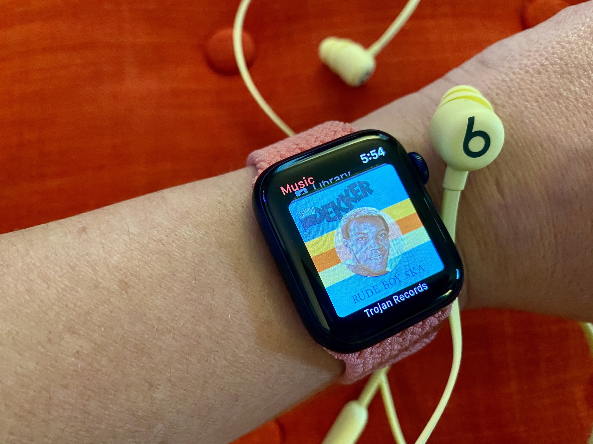 Beats Flex next to Apple Watch playing Apple Music