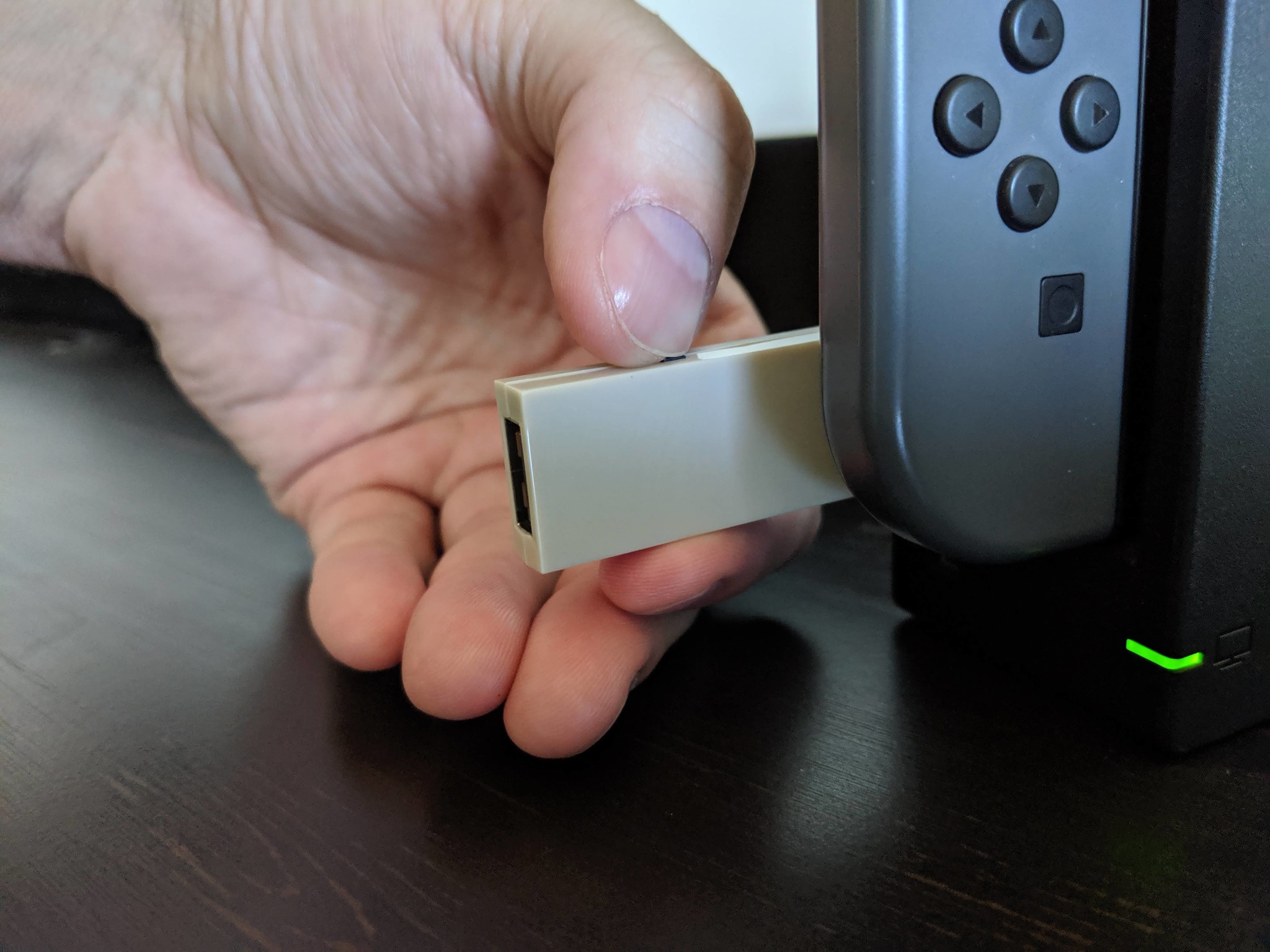 How to connect your Xbox One controller with the Nintendo Switch in wireless docked mode step two: hold down the small black button on the adapter for 3-5 seconds until it changes modes