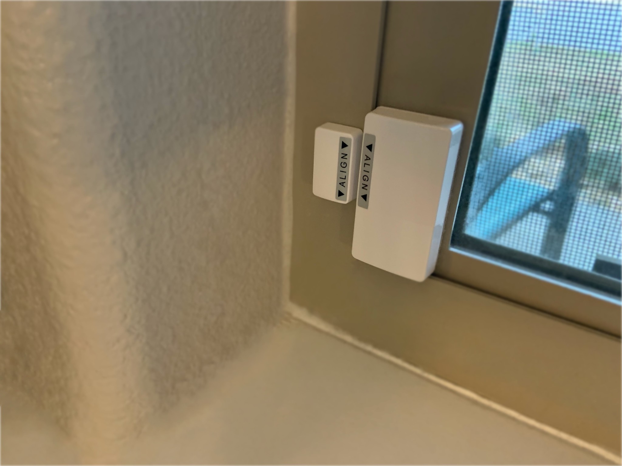 Abode Wireless Mini Sensor installed on a window
