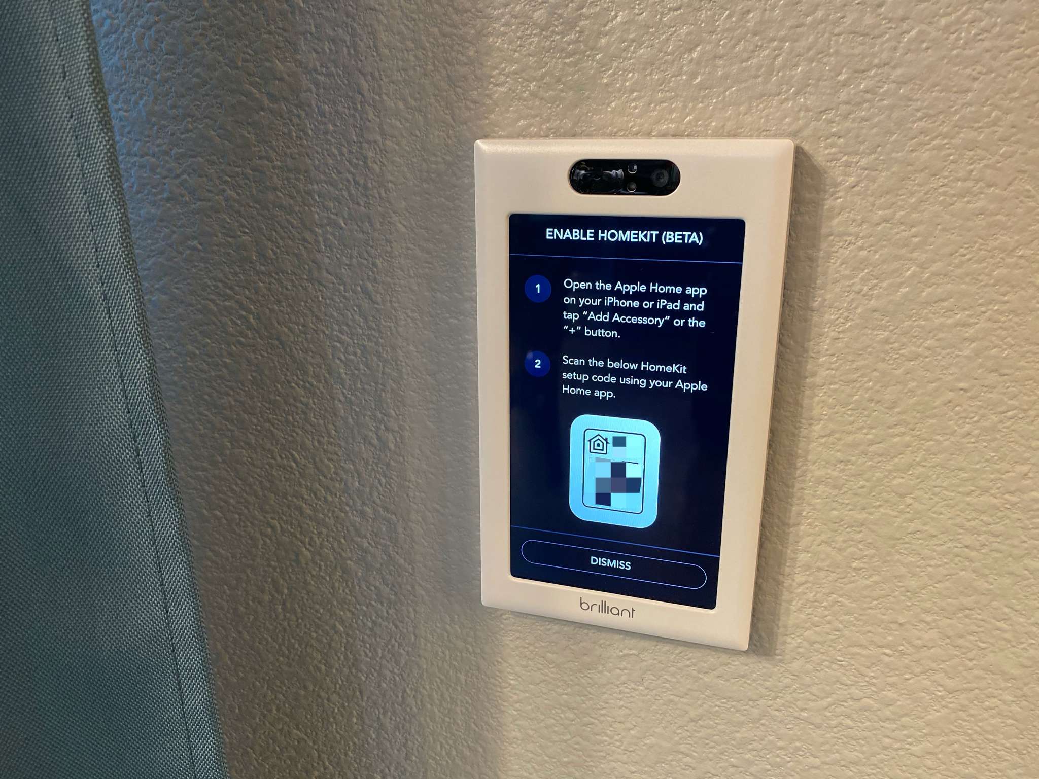 Brilliant Home Control installed on a wall with the HomeKit setup code on its display