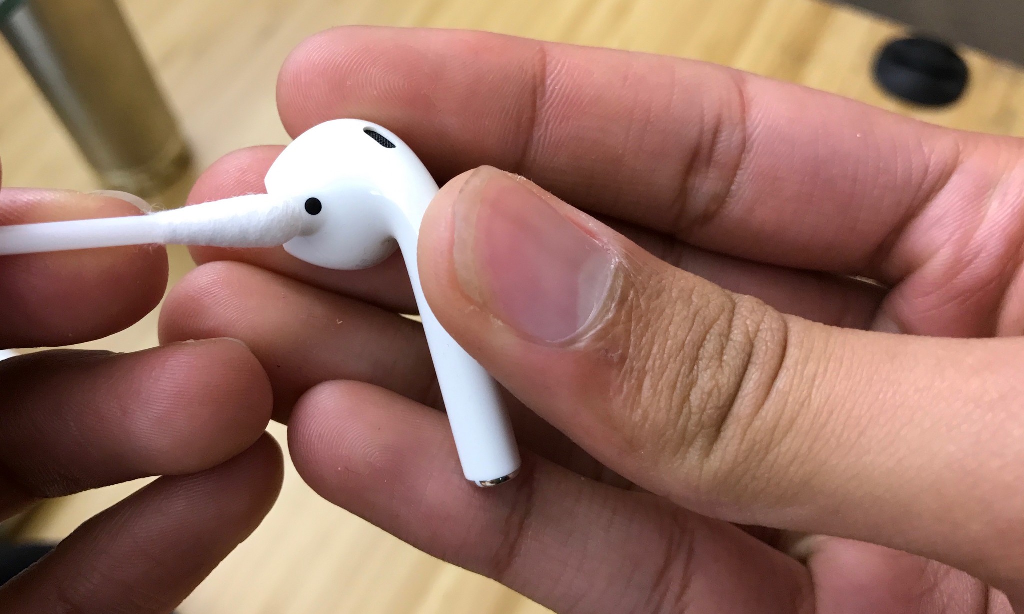 Using a cotton swab to do a thorough cleaning of AirPods