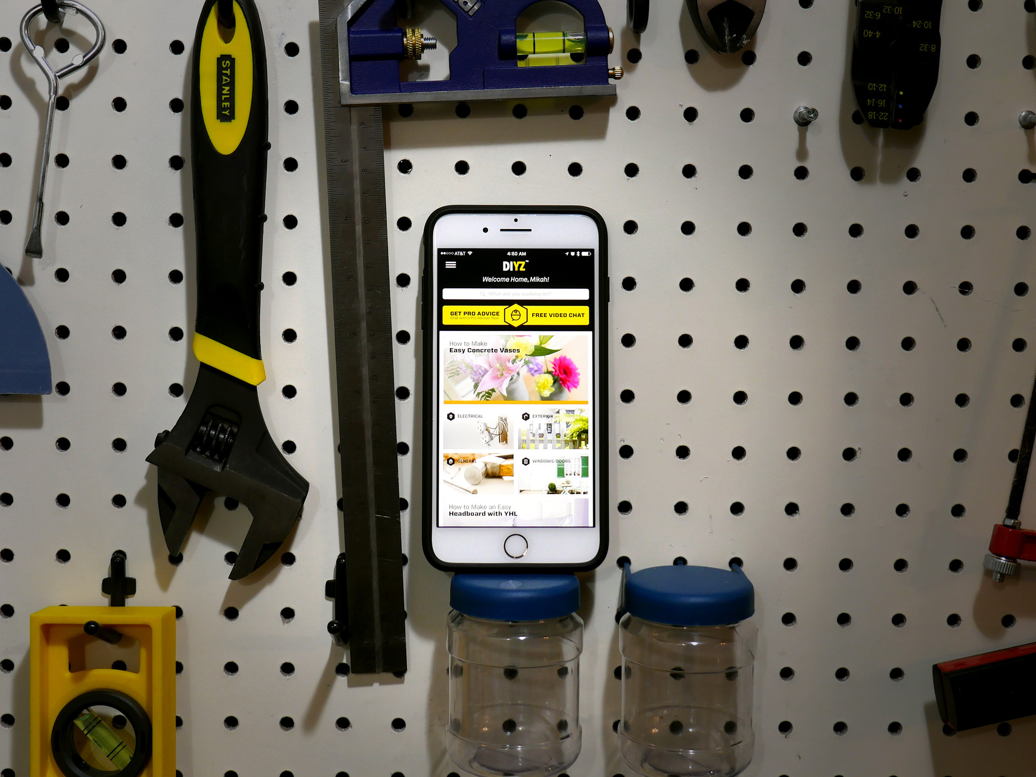 An iPhone is shown beside common household tools. The DIYZ app is launched and open on screen.