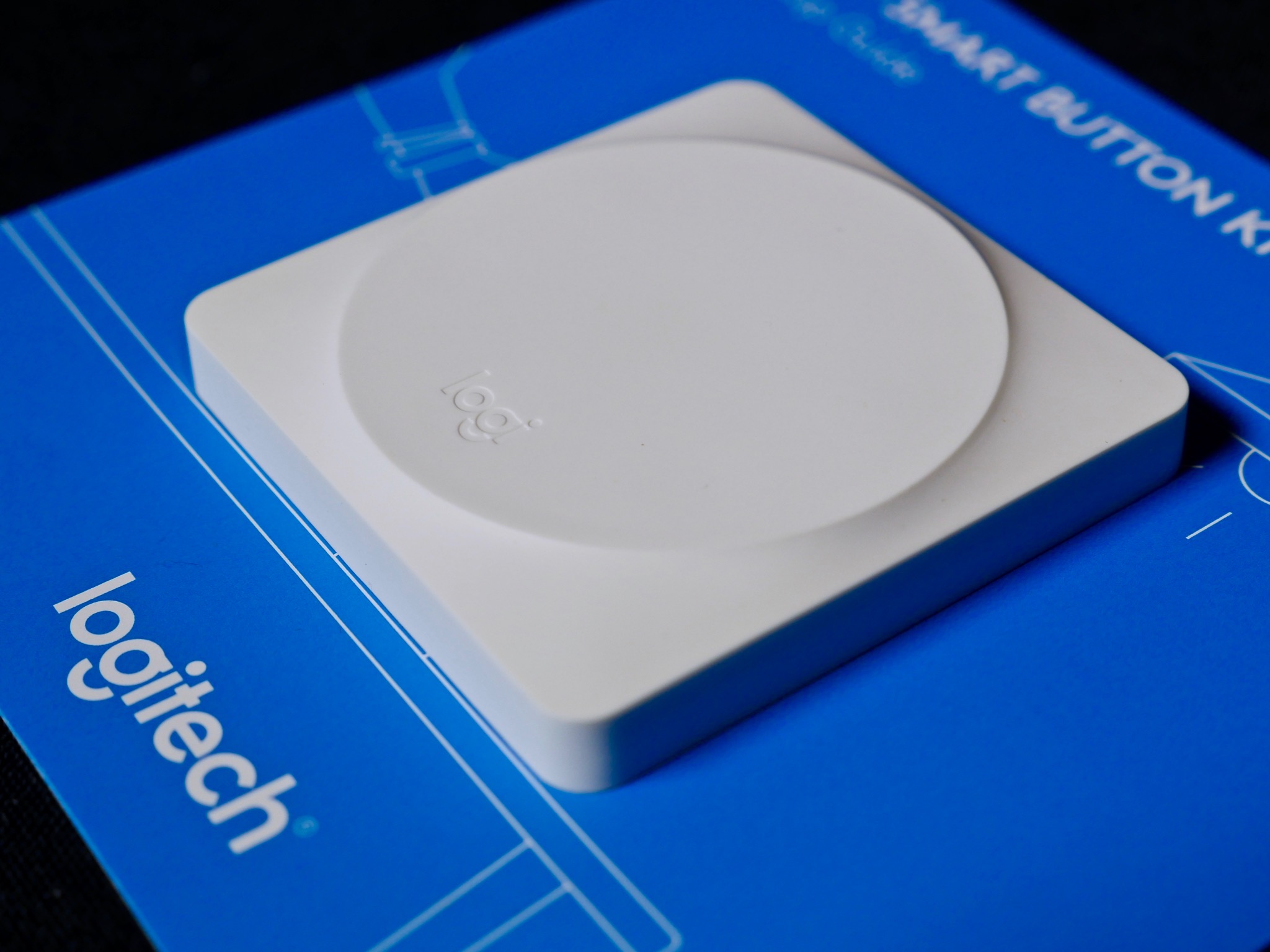 The Logitech POP Smart Button sits atop the blue Setup Guide.