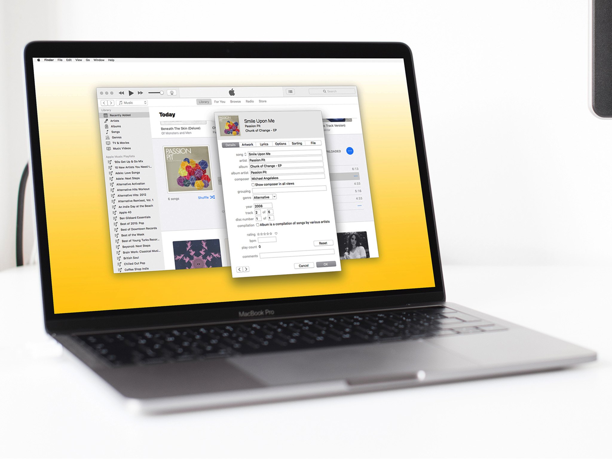 A MacBook Pro is shown with iTunes launched on screen. A song&#39;s metadata is being edited.